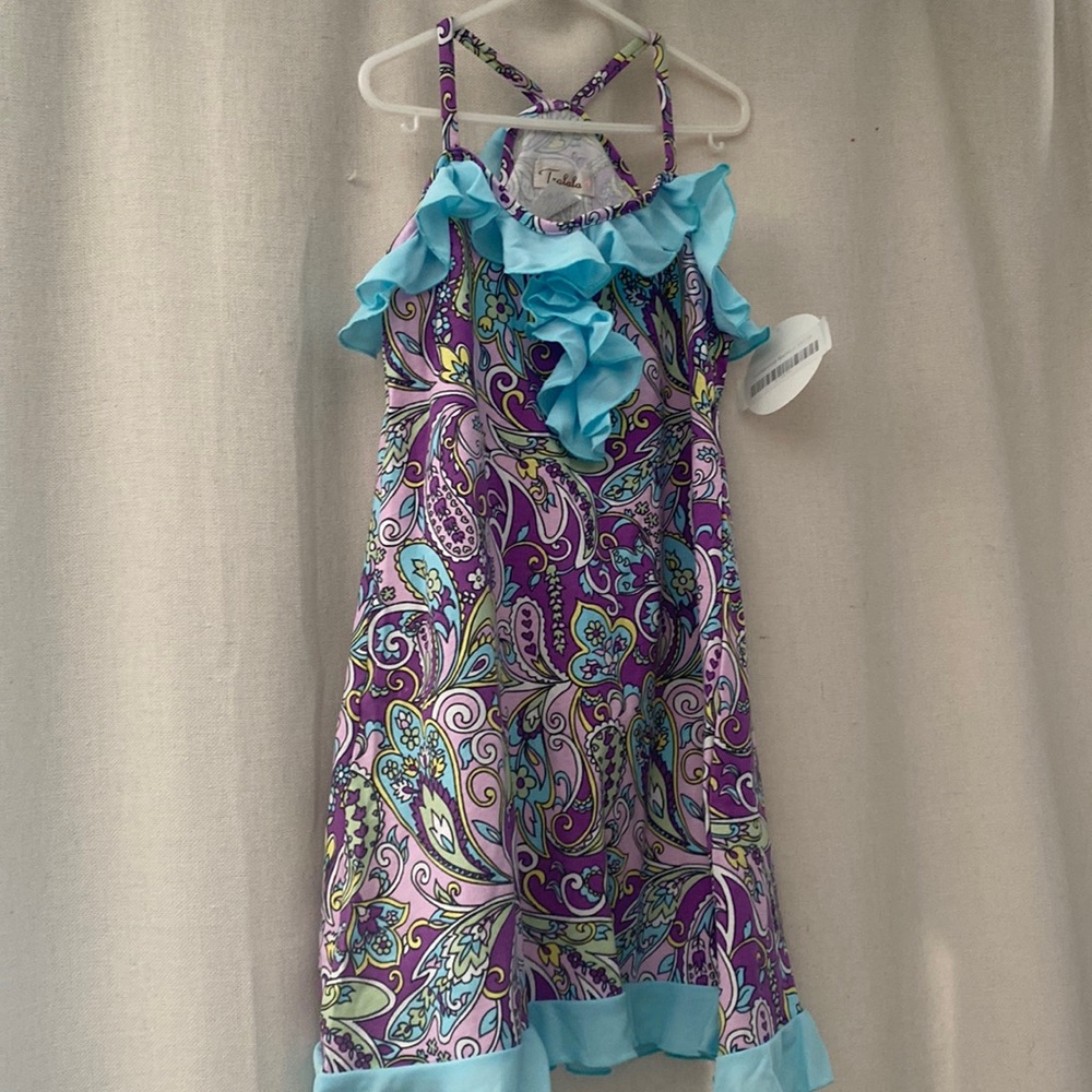Little girl’s dress wit cut in straps, with a flounce around and down the front